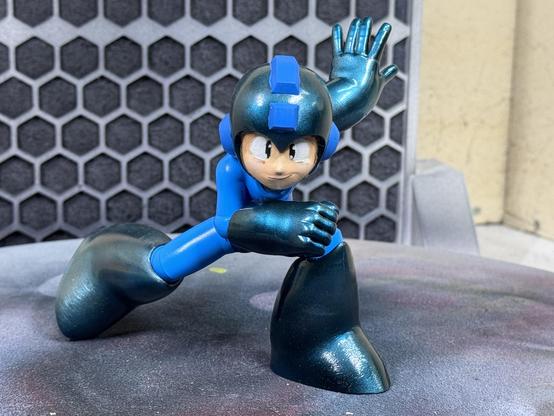 A 3d printed figure of Capcom‘s Mega Man. Hands, feet and helmet are painted in candy cobalt blue. Here the figure is shown from the front.