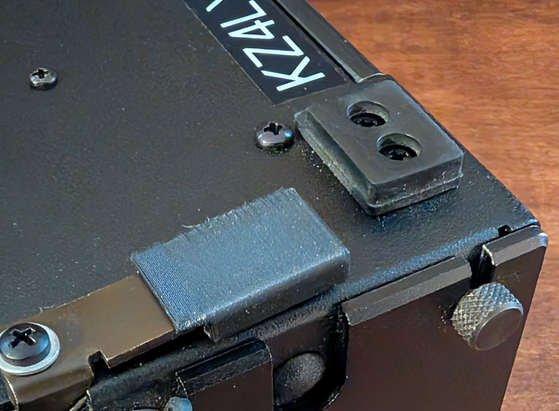 Photograph showing one of the 3d-printed feet installed on the radio it was made for, an Elecraft KX3