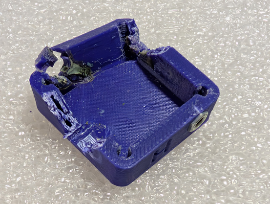 Damaged case with one side cracked off and pieces cut out for destructive disassembly to save the electrical parts for a new case.