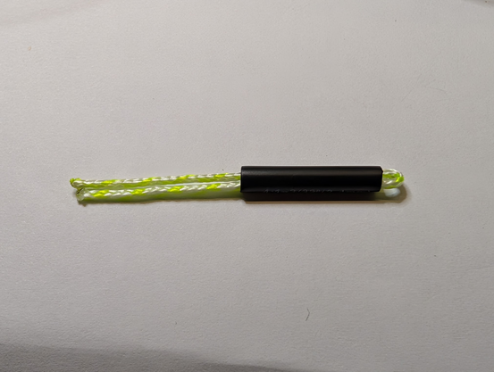 A piece of doubled dacron line partially inside a heat shrink tube