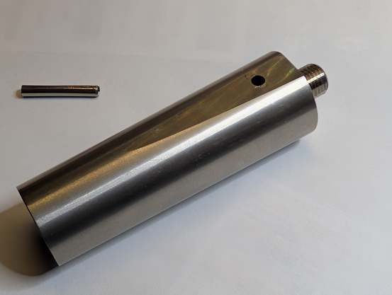 External view of base sleeve that fell off the whip. It has flat sides where the holes for the roll pin go, and is tapered from the base where a 3/8-24 threaded stud is visible towards the open end at the lower left.