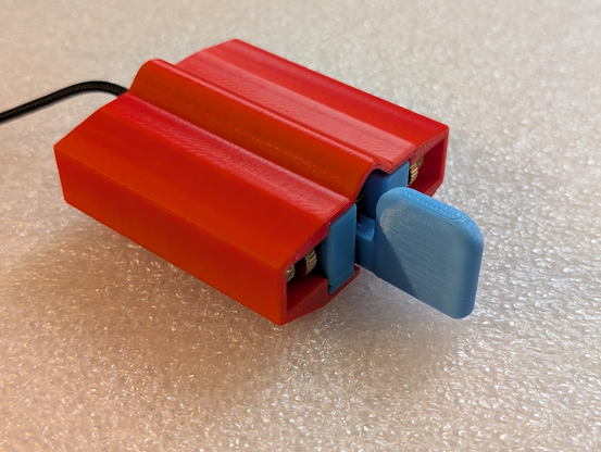 Photo of blue key in red grip/case, deployed in grip mode where the paddle sticks out.