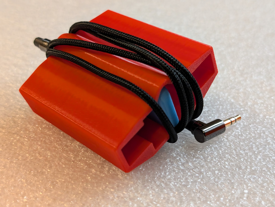 Photo of blue key in red grip/case, deployed in case mode. The key is fully retraced into the case, and the cable is wrapped around the whole unit.